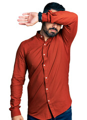 Sticker - Young hispanic man with beard wearing casual shirt covering eyes with arm, looking serious and sad. sightless, hiding and rejection concept