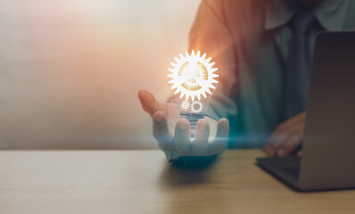 close-up of businessman's hand showing light bulb with cogwheel, concept innovation, creativity, ins