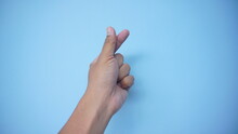 A Hand Signs Gesture To Be Little Heart From Tip Of Thumb And Index Finger On Blue Background