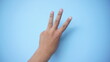 © MdzFahmi - Hand extended in greeting isolated on blue background. Number three.