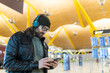 © ADDICTIVE STOCK - Stylish male traveler using smartphone in airport