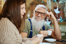 Hipster Grandfather With Granddaughter Drinking Coffee At Cafe