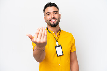 Wall Mural - Young Arab man with ID card isolated on white background inviting to come with hand. Happy that you came