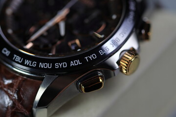 close up shallow focus Time zone cities code on luxury world time watch bezel, SYD Sydney, ADL Adelaide, NEU Neumea, TYO Tokyo.