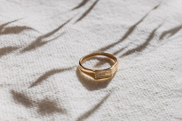 Wall Mural - Golden ring in natural light close-up. Minimalist jewelry