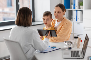 Poster - medicine, healthcare and pediatry concept - smiling mother with little son and doctor with tablet pc computer at clinic