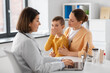 © Syda Productions - medicine, healthcare and pediatry concept - mother with little coughing son and doctor with laptop computer at clinic