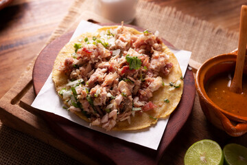 Wall Mural - Taco de Carnitas. Cornmeal tortilla with deep fried pork. Traditional Mexican appetizer commonly accompanied by cilantro, onion and hot sauce.