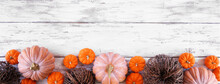 Fall Bottom Border Of Pumpkins And Natural Decor Over A Rustic White Wood Banner Background. Above View With Copy Space.