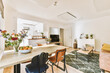 © Casa imágenes - Contemporary minimalist style interior design of light studio apartment with wooden table and chairs in dining zone between open kitchen and living room with white walls and parquet floor
