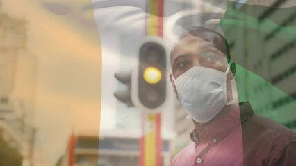 Canvas Print - Animation of flag of ivory coast waving over caucasian man wearing face mask in city street