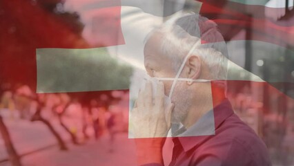 Poster - Animation of flag of switzerland waving over caucasian man wearing face mask in city street