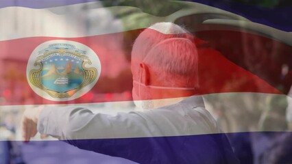 Wall Mural - Animation of flag of costa rica waving over caucasian man wearing face mask in city street