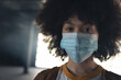 © Wavebreak Media - Portrait of mixed race woman wearing face mask looking to camera