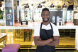 © Wavebreak Media - Portrait of african american male barista looking at the camera and smiling