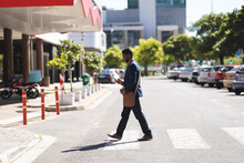 African American Man Crossing The Road Using Smartphone
