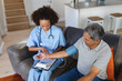 © Wavebreak Media - Senior mixed race man with female doctor home visiting taking blood pressure