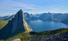 View from the mount Hesten on iconic mountain Segla in a summer sunny day. Mountain ranges at the background. Fjordgard, Senja island, Norway. Summer vacation in Lofoten   