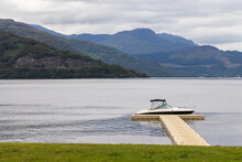 Idyllic Lake Front Mooring. Small Boat Moored On A Loch In Scotland UK. Calm Landscape.