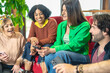 © Vittorio Gravino - Multiracial friends checking on smartphone a new trends of social network  - Room mates socializing in new their home while having fun in living room