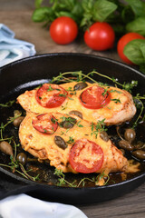 Wall Mural - Tender chicken breast baked with tomatoes, capers, herbs under cheese crust in a frying pan