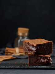 Canvas Print - Baked pieces of chocolate brownie pie on black table, delicious dessert