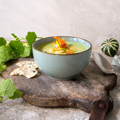 Wall Mural - a bowl of creamy zucchini soup with shrimp on a light table