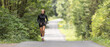 Young female athlete runs up the hill on an asphalt road in the nature