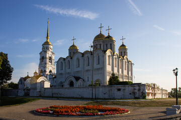 Ancient white stone Assumption Cathedral with golden domes on a clear summer sunny day and blue clear sky in vladimir russia