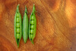 © Татьяна Яблокова - Fresh three green peas on wood texture background. Pea pods are opened.