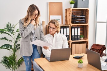 Wall Mural - Man and woman business workers using laptop working at office