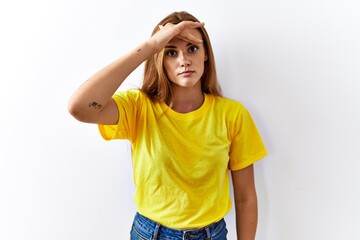 Wall Mural - Young brunette woman standing over isolated background worried and stressed about a problem with hand on forehead, nervous and anxious for crisis