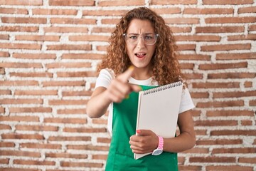 Sticker - Young caucasian woman holding art notebook pointing displeased and frustrated to the camera, angry and furious with you