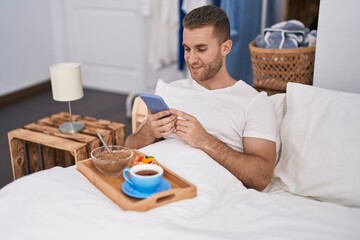 Wall Mural - Young caucasian man make photo by smartphone to breakfast at bedroom