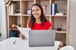 © Krakenimages.com - Young african american woman using laptop reading document sitting on table at home