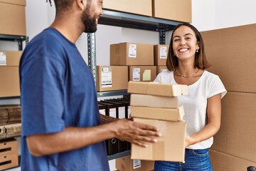 Sticker - Man and woman business partners smiling confident holding packages at storehouse