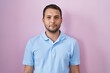 © Krakenimages.com - Hispanic man standing over pink background relaxed with serious expression on face. simple and natural looking at the camera.
