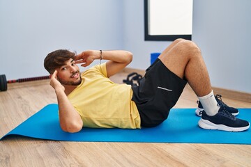 Poster - Young arab man smiling confident training abs exercise at sport center