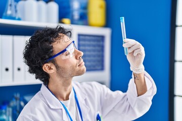 Sticker - Young hispanic man scientist holding test tube at laboratory