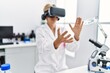 © Krakenimages.com - Middle age blonde woman wearing scientist uniform using vr goggles working at laboratory