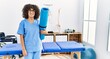 © Krakenimages.com - Young middle east woman wearing physio therapist uniform holding yoga mat at clinic