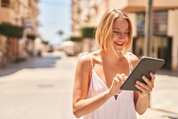 Poster - Young blonde woman smiling confident using touchpad at street