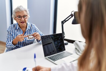 Wall Mural - Senior grey-haired woman patient having medical consultation holding pills at clinic