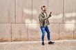© Krakenimages.com - Young hispanic man smiling confident listening to music and dancing at street