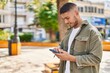 © Krakenimages.com - Young hispanic man smiling confident using smartphone at park