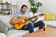 © Krakenimages.com - Middle age caucasian man smiling confident playing classical guitar at home