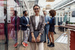 © Kostiantyn - Portrait of smiling businesswoman in glasses standing in modern office on colleagues background