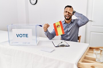 Poster - Young handsome man with beard at political campaign election holding spain flag stressed and frustrated with hand on head, surprised and angry face