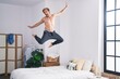 © Krakenimages.com - Young man jumping on bed at bedroom