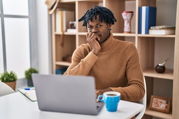 Sticker - Young african man with dreadlocks working using computer laptop looking stressed and nervous with hands on mouth biting nails. anxiety problem.